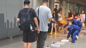 台风暴雨后出现积水，消防员用排水管搭了座便民“水带桥”