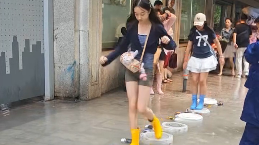暴雨积水阻归路,消防水带搭起“便民桥”