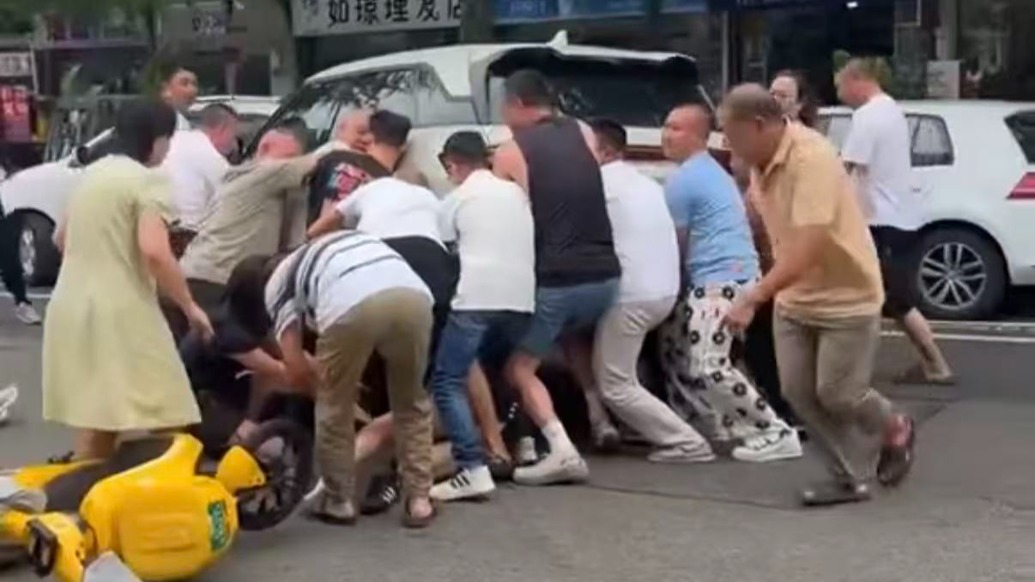 “不可能见死不救”,女孩被卷入车底命悬一线,数十位路人徒手抬车