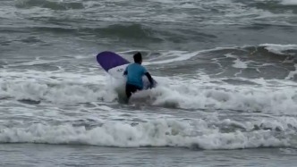 冲浪教练抱起板冲入巨浪救人，俱乐部发声：很多路人有心施救但浪太大，溺水孩子无大碍