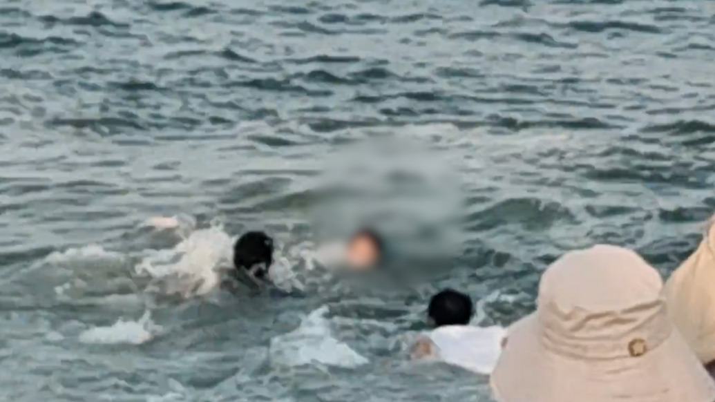 海浪瞬间吞没女孩,下一幕两个身影飞身跃下救人,岸边的他们也纷纷伸出援手