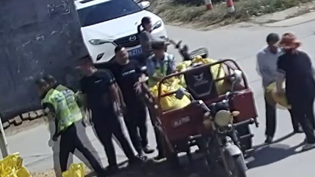 三轮车侧翻后玉米散落一地,附近交警、路人上前帮忙捡拾