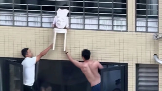 幼童头卡12楼防护网身体悬空：邻居、保安在11楼探出窗外托举，家长在业主群致谢