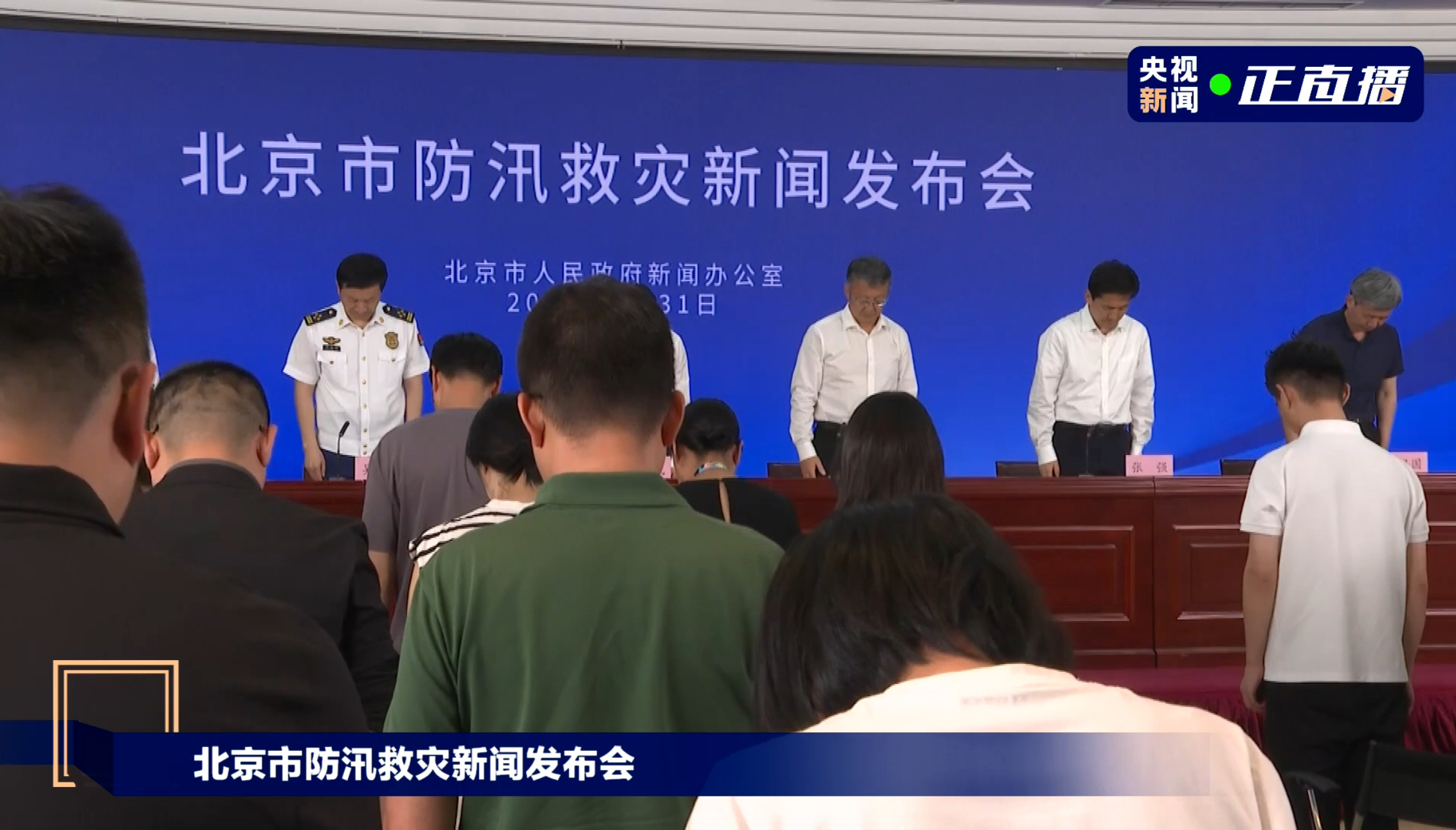 北京市防汛救灾新闻发布会现场为遇难者默哀