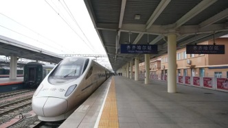齊齊哈爾站售票窗口前，工作人員給旅客發(fā)小紙條？